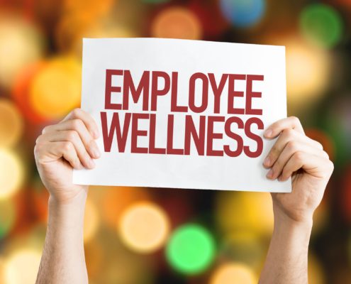 a person holding a employee wellness sign
