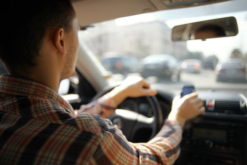 a person checking his phone while driving a car