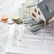 home insurance papers with money and a house model on it