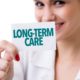 a lady holding a piece of paper with long term care on it