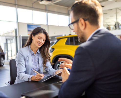 woman is discussing embedded auto insurance with salesman
