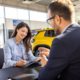 woman is discussing embedded auto insurance with salesman