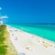 a florida beach with the sea on one side and buildings on the other
