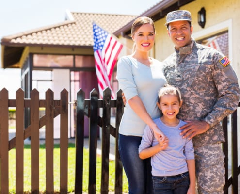 an american army officer standing next to her family in front of their house
