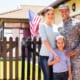 an american army officer standing next to her family in front of their house