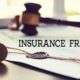 Insurance fraud text on legal document with gavel and wax seal on desk
