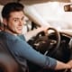 Young driver smiling behind the wheel of a car