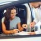 a woman sitting in her new car signing collateral protection insurance