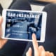 a person signing up for car insurance on an ipad
