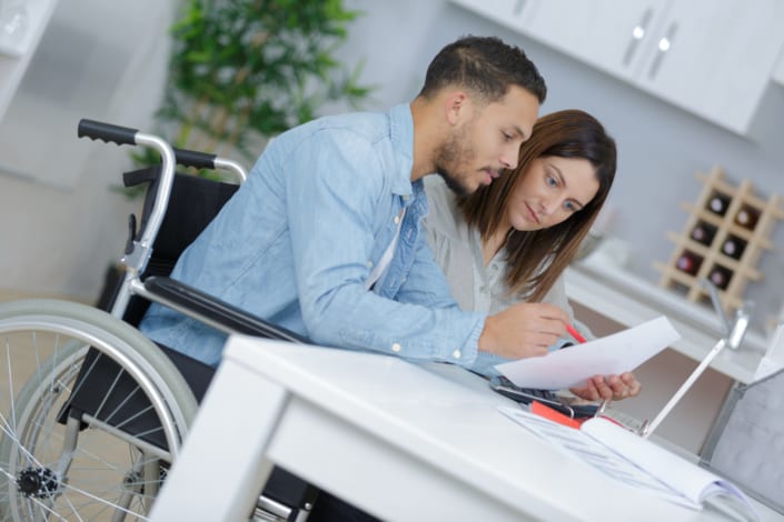 a couple with a disabled husband reviewing disability insurance papers
