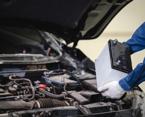 a car mechanic installing a new battery in a car