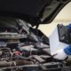 a car mechanic installing a new battery in a car