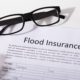 flood insurance papers on a table with eye glasses on them