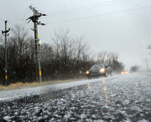 cars driving on a road while its hailing