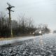 cars driving on a road while its hailing