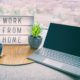 Work from home office setup with laptop and sign