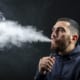 a guy vaping with smoke blowing out of his mouth