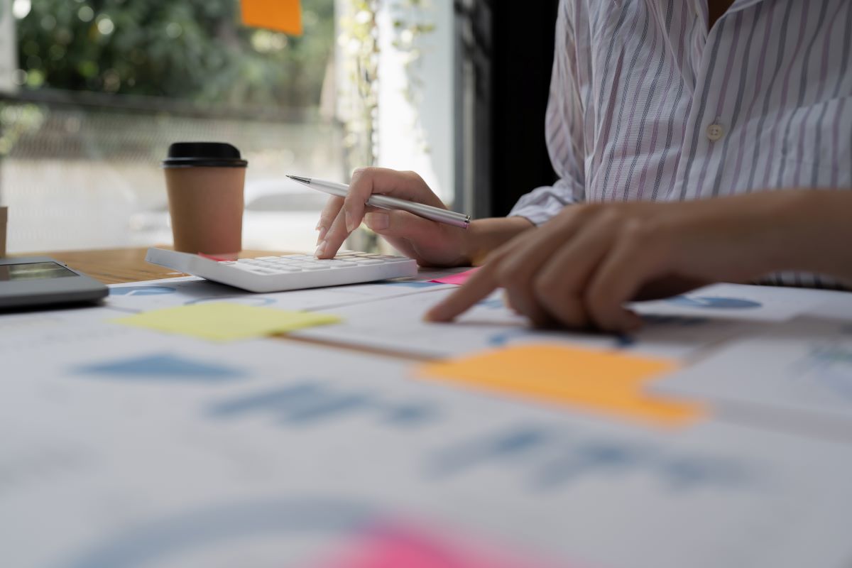 Business professional calculating expenses and reviewing financial documents at desk