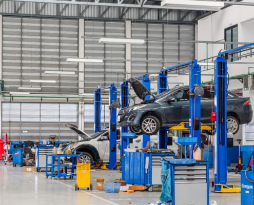a car mechanic shop with cars being worked on
