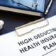 high deductible health plans written on a piece of paper on a table