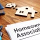 a table with house figure on the table next to a homeowner association papers