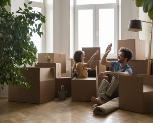 a father daughter surrounded by moving boxes in their new house