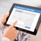 Person submitting insurance claim form online on tablet screen
