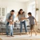 a family dancing together in their house living room