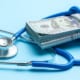 Stack of US dollar bills wrapped in a stethoscope, symbolizing healthcare costs or medical insurance expenses.
