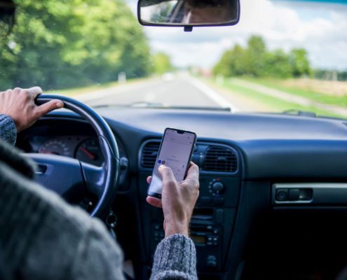a man driving his car down the road while texting
