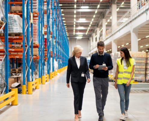 1 guy and 2 ladies walking around in a facility