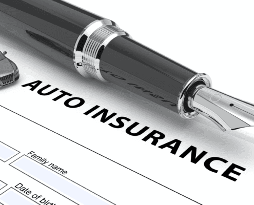 Auto insurance document with fountain pen and miniature car.