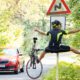 Cyclist losing control and colliding with road sign while car approaches