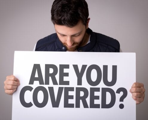 a guy holding a sign saying "are you covered?"