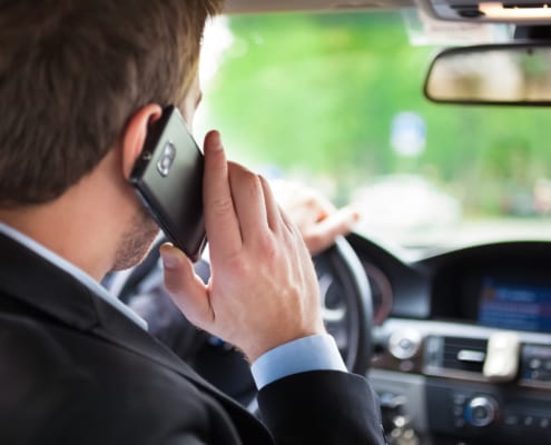 a man talking on his phone while driving a car