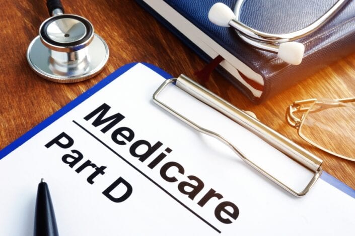 a clipboard with medicare part d written on it with a pen on it