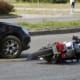 a motorcycle on the ground after being hit by a car