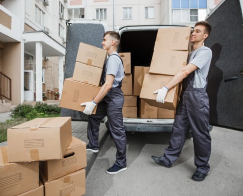 movers unloading cardboard boxes from the back of a van