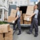 movers unloading cardboard boxes from the back of a van