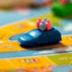 Toy family riding in car on board game representing family auto insurance