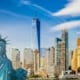 Statue of Liberty in front of the New York City skyline on a clear day.