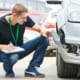 insurance agent inspecting a broken car bumper