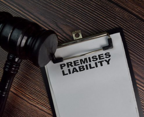 Premises liability document on clipboard with judge gavel on wooden desk
