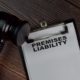 Premises liability document on clipboard with judge gavel on wooden desk