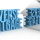 a silver house figure next to a reverse mortage sign getting reflected onto it