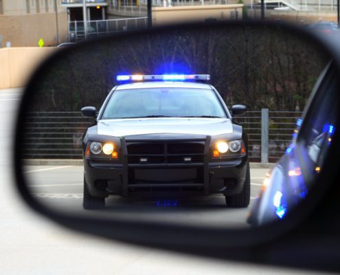 a police car in the side view mirror of a car
