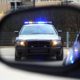 a police car in the side view mirror of a car