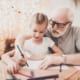 a grandma showing his grand daughter how to draw