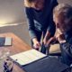 Senior couple reviewing life insurance documents at home with laptop and paperwork