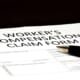 Close-up of a worker’s compensation claim form on a desk with a pen resting on top